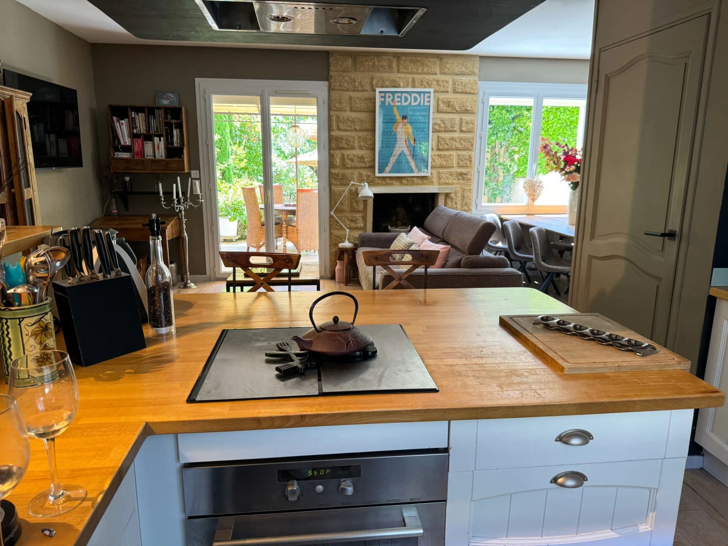 Kitchen and living room at Nid d'Ange en Provence View of a modern and cozy kitchen opening onto the living room, with direct access to the green terrace at Nid d'Ange en Provence.