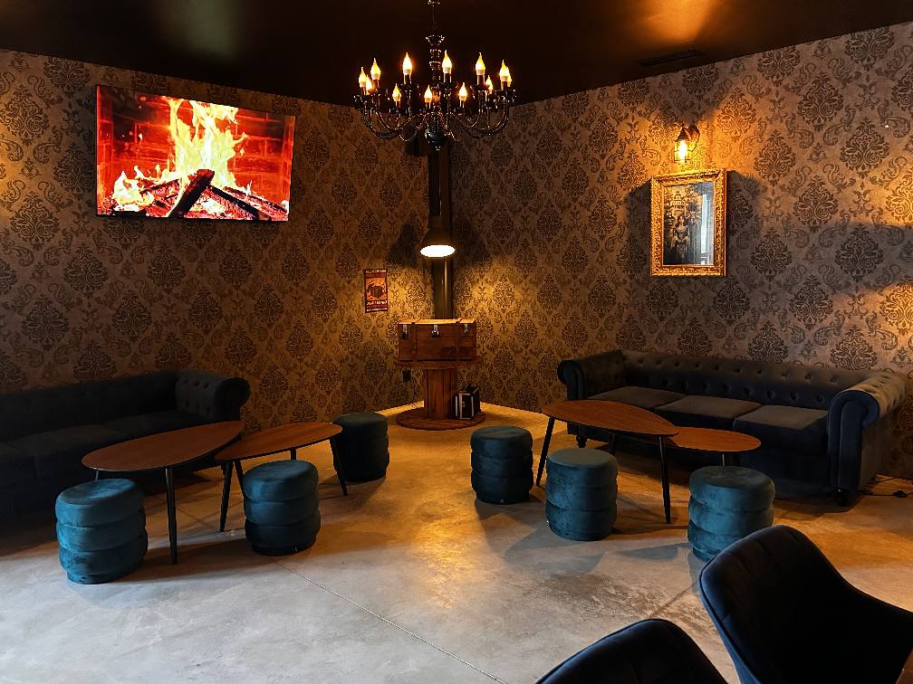 Lounge area at Last Adventures with sofas, soft lighting and a fireplace screen