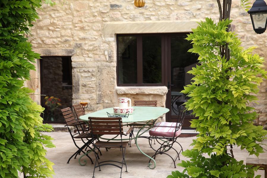 Shaded terrace with garden furniture at La Petite Maison des Garrigues in the Luberon