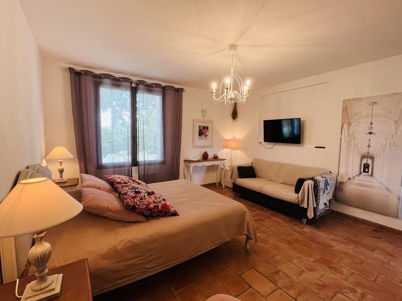 Double bed in an elegant, bright room with floral cushions