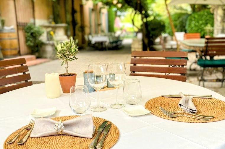 Set table on the terrace of the Sous les Platanes restaurant at Mas des Grès