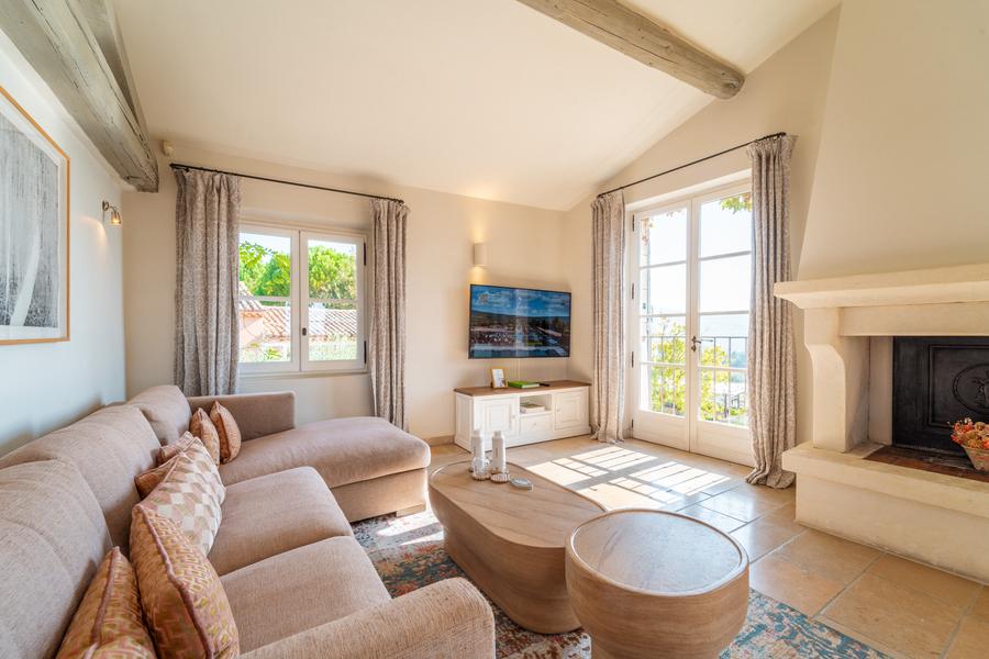 Bright living room in a Coquillade Provence suite with fireplace and outdoor view