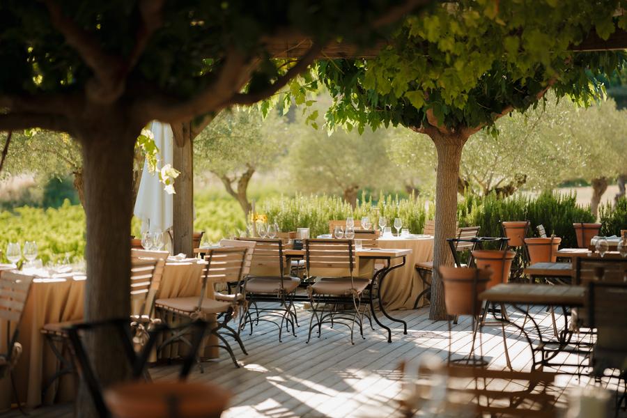 Shaded terrace of the Coquillade Provence restaurant overlooking the vineyards