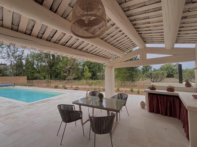 Shaded terrace with summer kitchen and pool view at Jas de la Cascade in Cavaillon