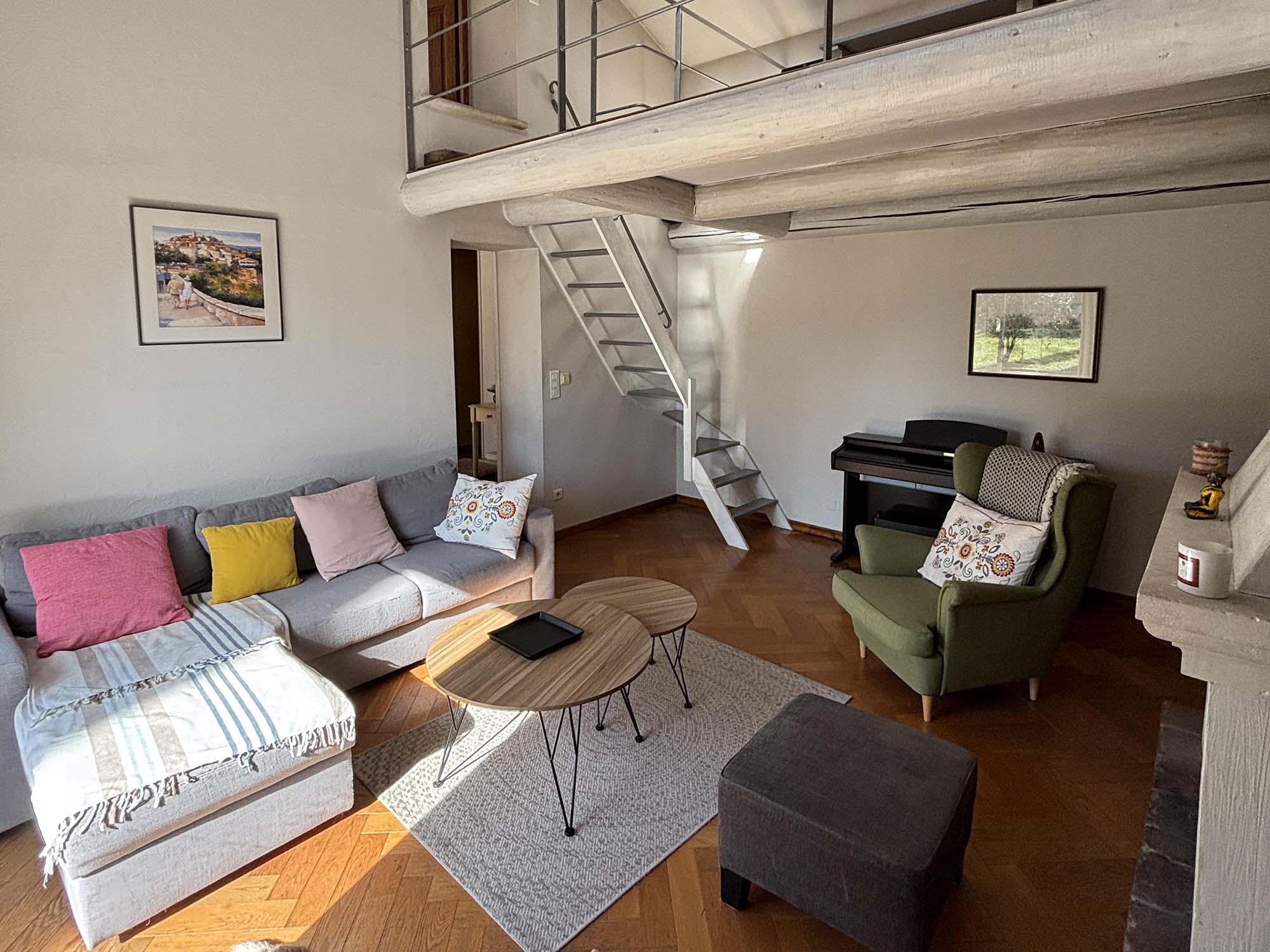 Bright living room in the Mas Provençal in Cavaillon with mezzanine, sofa and piano