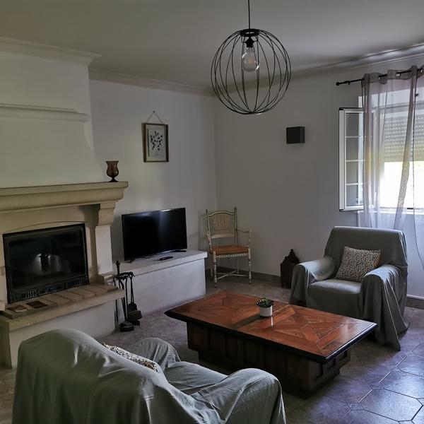 Bright living room with fireplace in a holiday home in Cheval-Blanc