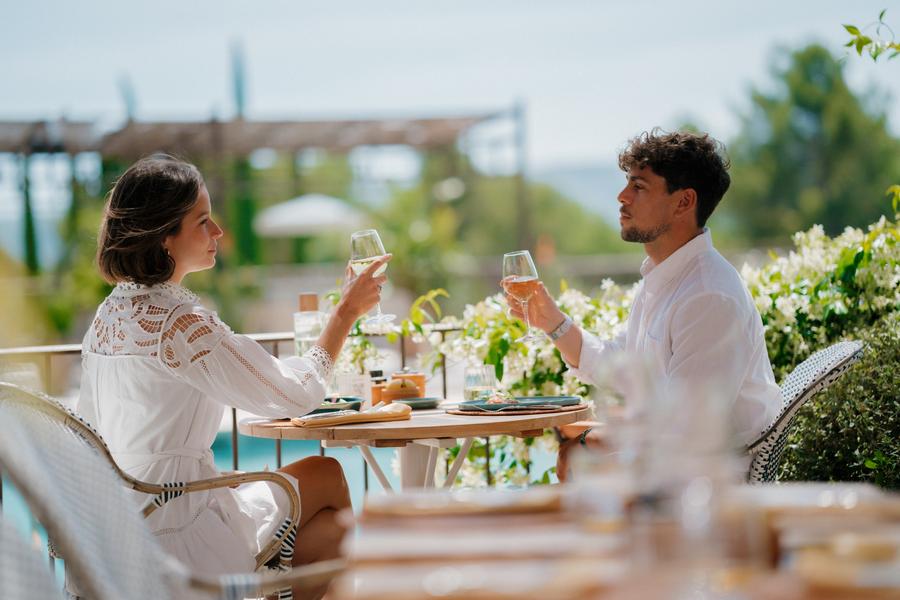 Couple having lunch on the terrace at Cipressa restaurant in Coquillade Provence, with views over the Luberon