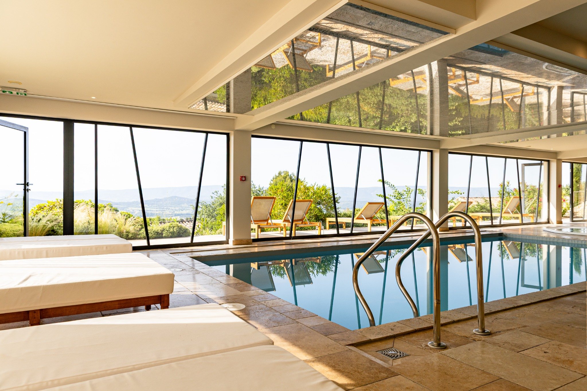 Indoor pool of the Mas des Herbes Blanches spa overlooking the landscapes of the Luberon