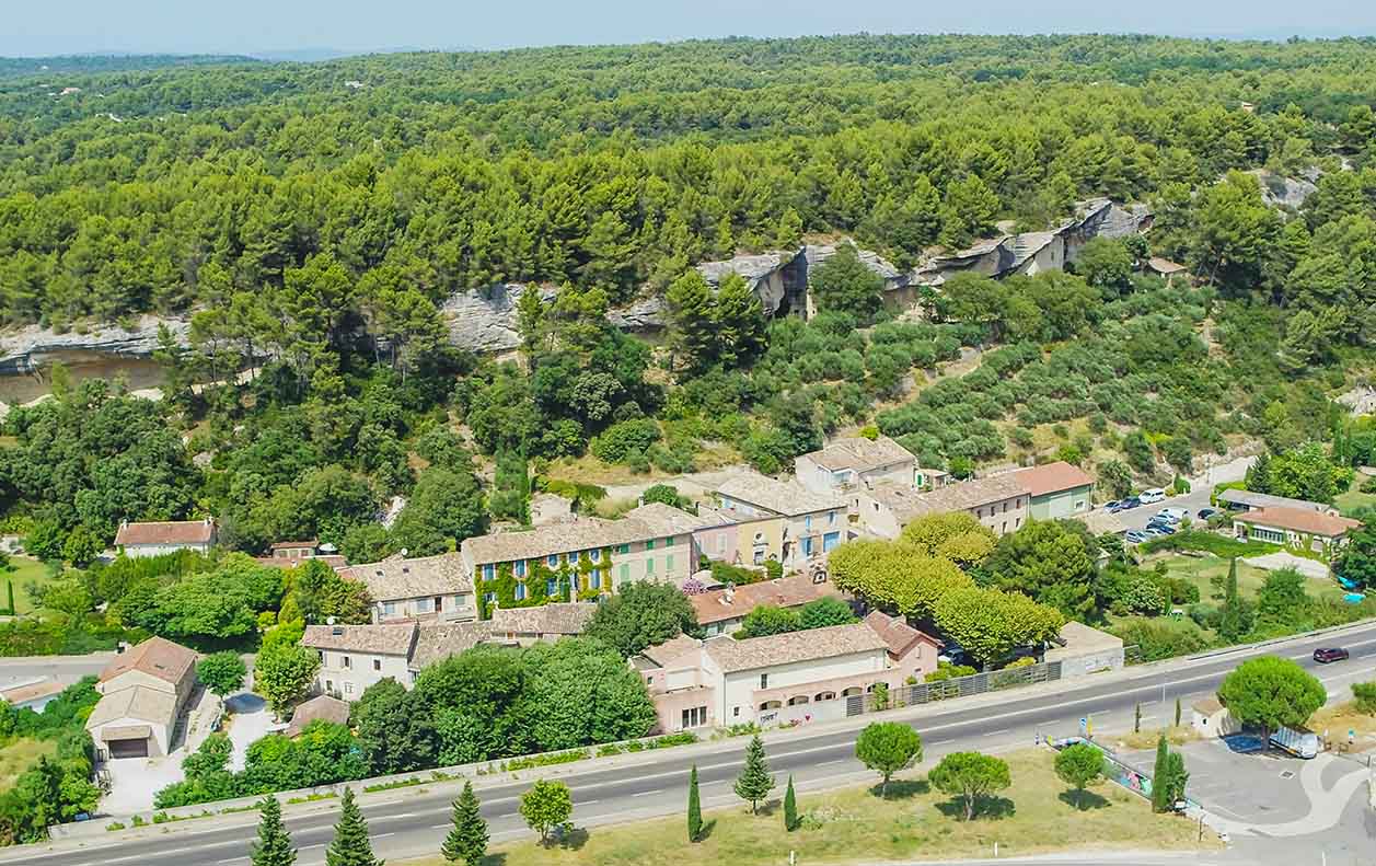 Aerial view of the village of Les Beaumettes and its troglodyte houses at the foot of the hillside, in the Luberon