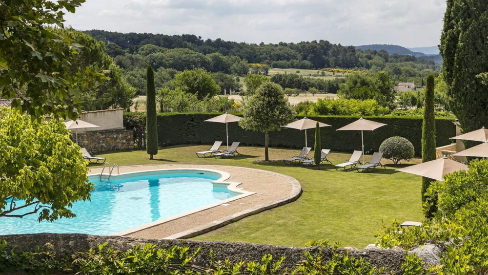 Swimming pool and garden of Mas de Guilles in Lourmarin overlooking the Luberon countryside