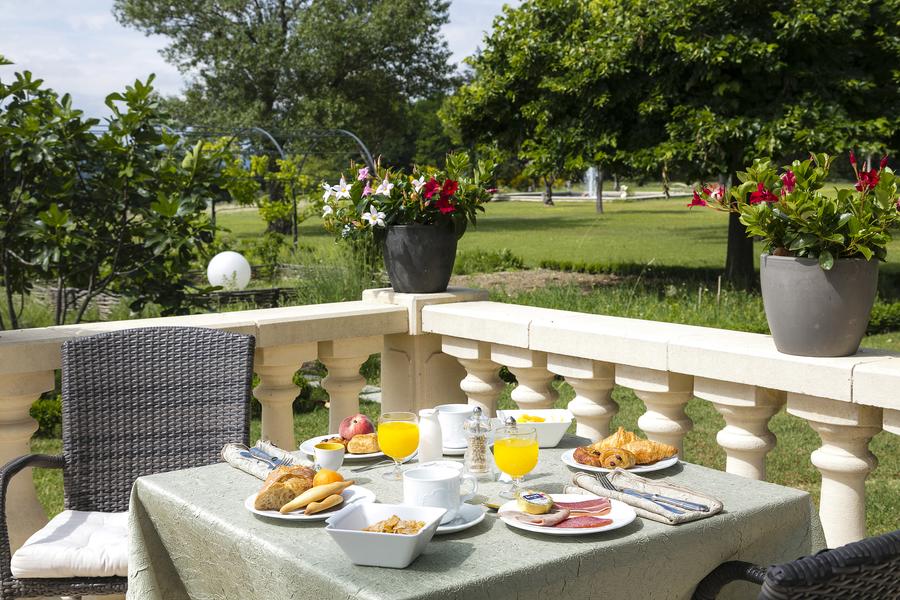 Breakfast served on the terrace overlooking the park at Le Mas de Guilles