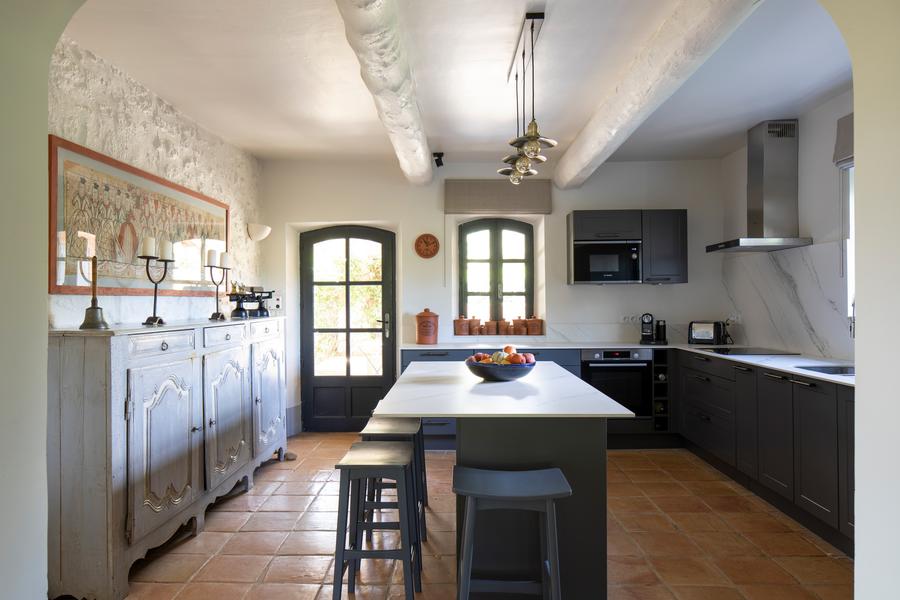 Modern and bright kitchen at Mas Petit Collongue with central island and access to the terrace