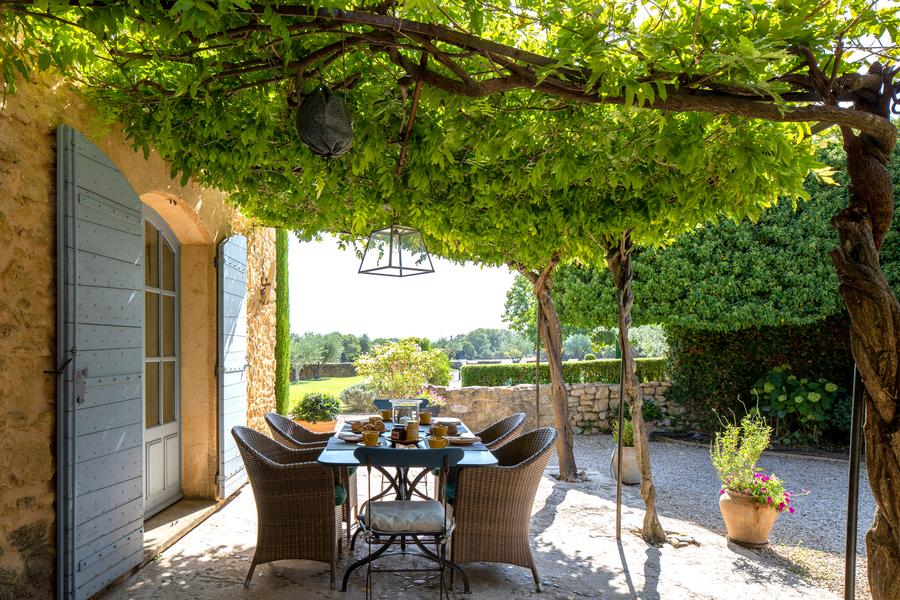 Shaded terrace under a leafy pergola at Mas Petit Collongue in Lourmarin