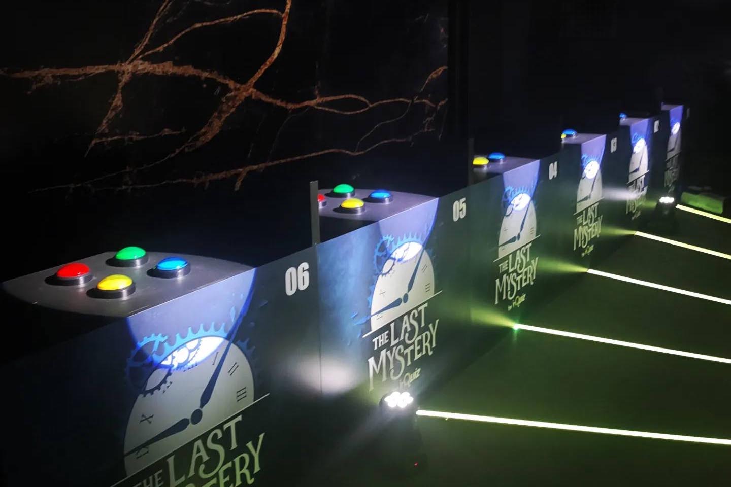 Quiz Game set at The Last Mystery with numbered podiums and colorful buzzers in a TV-style setup