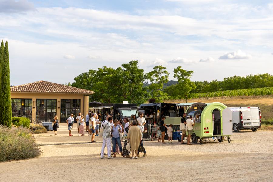 Food trucks and visitors in the grounds of Château de Sannes during Festival Passions en Luberon