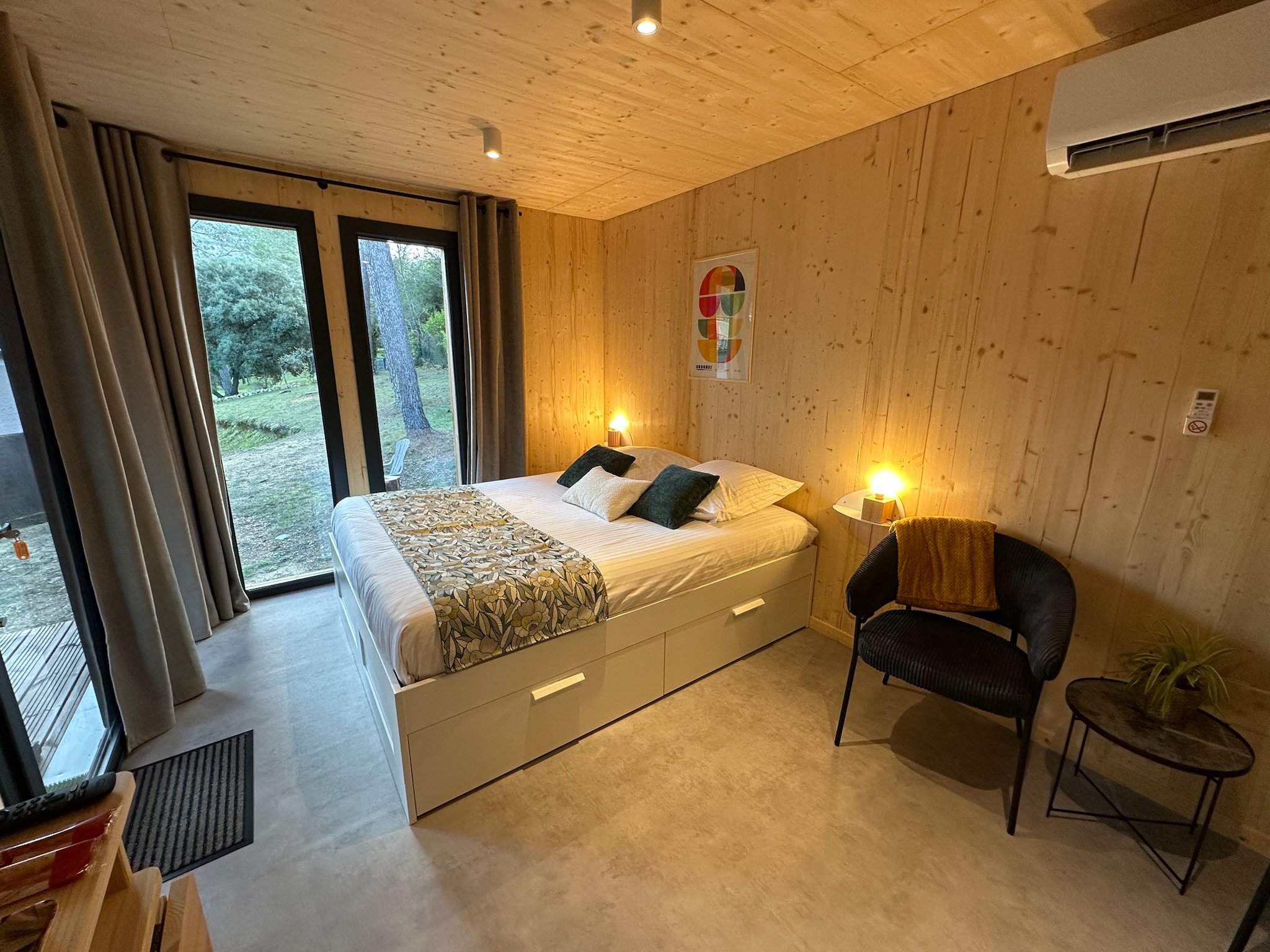 Double bed inside the Bird in Provence cabin with botanical decor and views of the garden