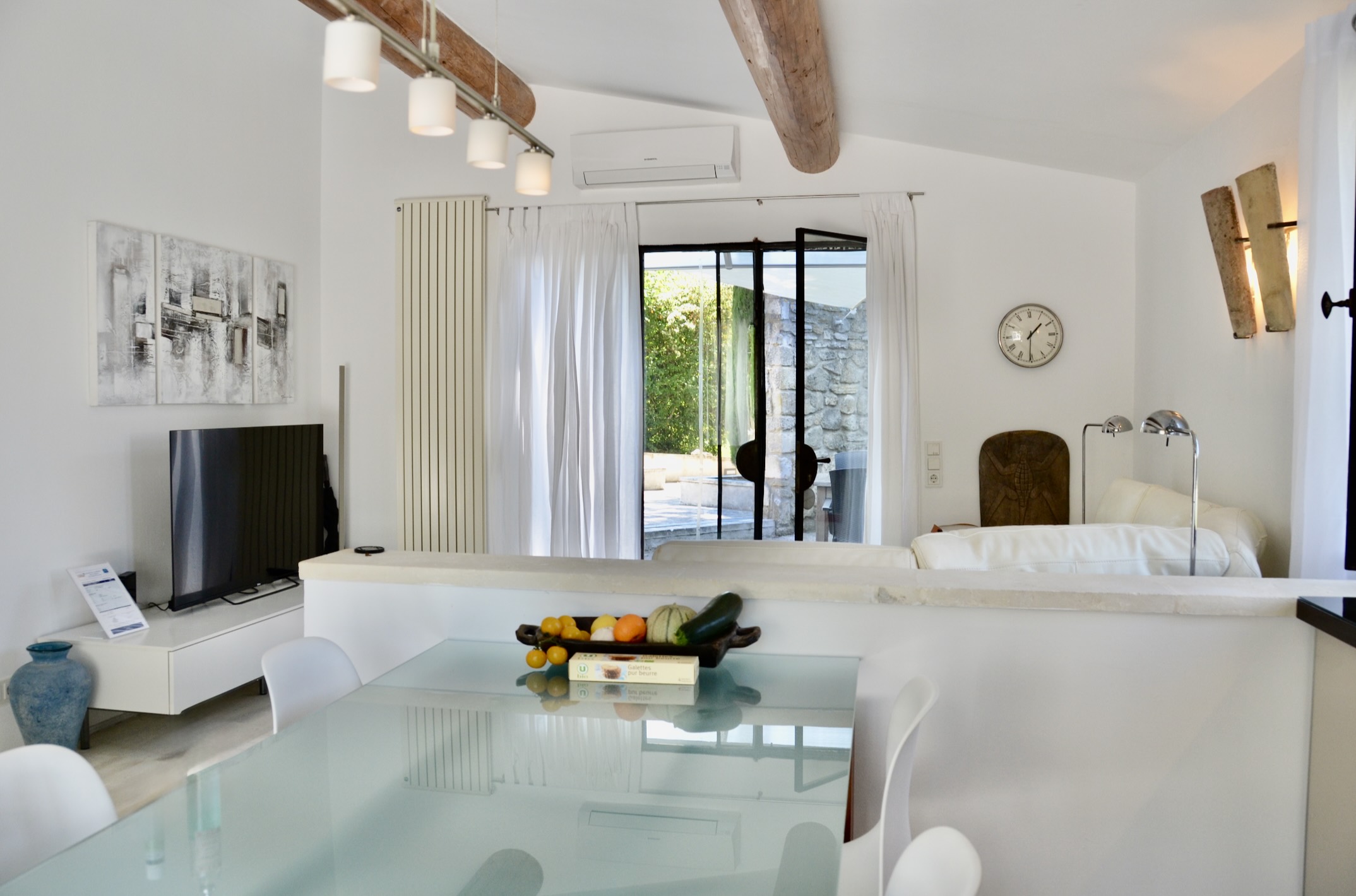 Contemporary living room and kitchen, charming house Les Oliviers in Oppède Bright living room with contemporary sofa and fully equipped open kitchen in Les Oliviers house in Oppède, Luberon