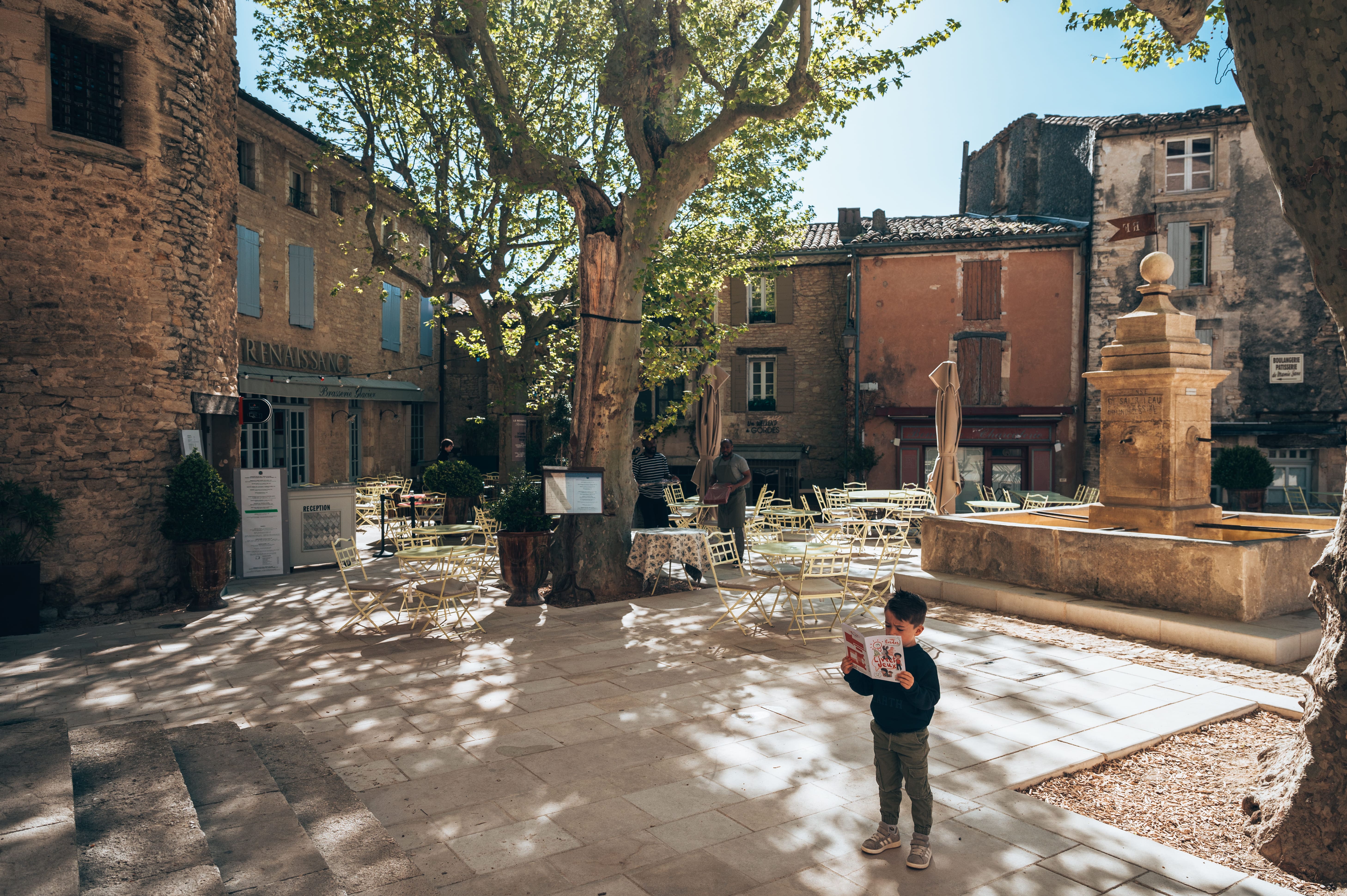 Children exploring a village in the Luberon with an activity booklet and looking for clues in the streets
