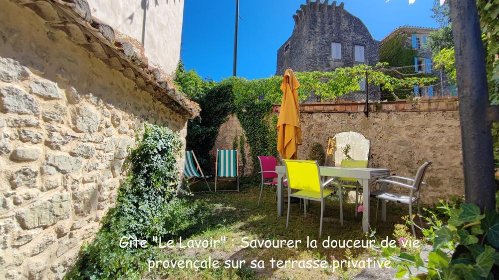 Private terrace at Le Lavoir holiday cottage with outdoor furniture and parasol