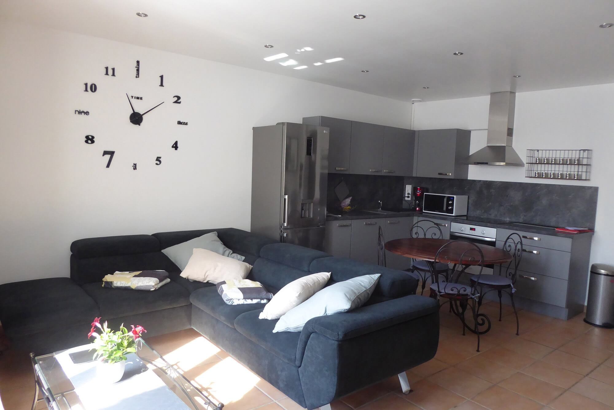Heller Wohnbereich der Ferienwohnung in Gordes mit gemütlichem Wohnzimmer und voll ausgestatteter offener Küche
