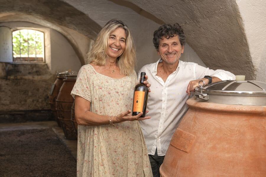Winemakers from Château Constantin presenting a bottle in the cellar in Lourmarin