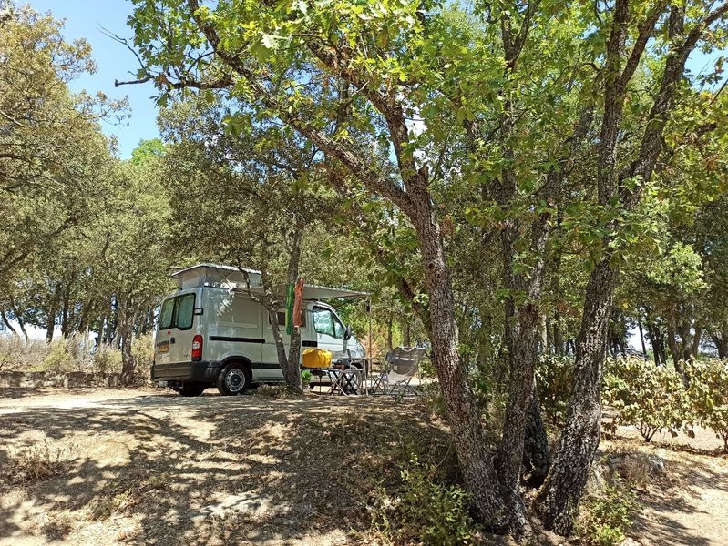 Spacious shaded pitches for tents, vans or motorhomes, Camping Le Moulin à Vent Converted van set up under the trees on a pitch at Camping Le Moulin à Vent