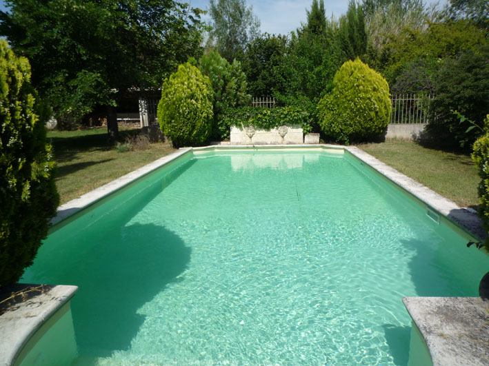 Stone swimming pool in Mediterranean garden at Mas des 2 Fontaines
