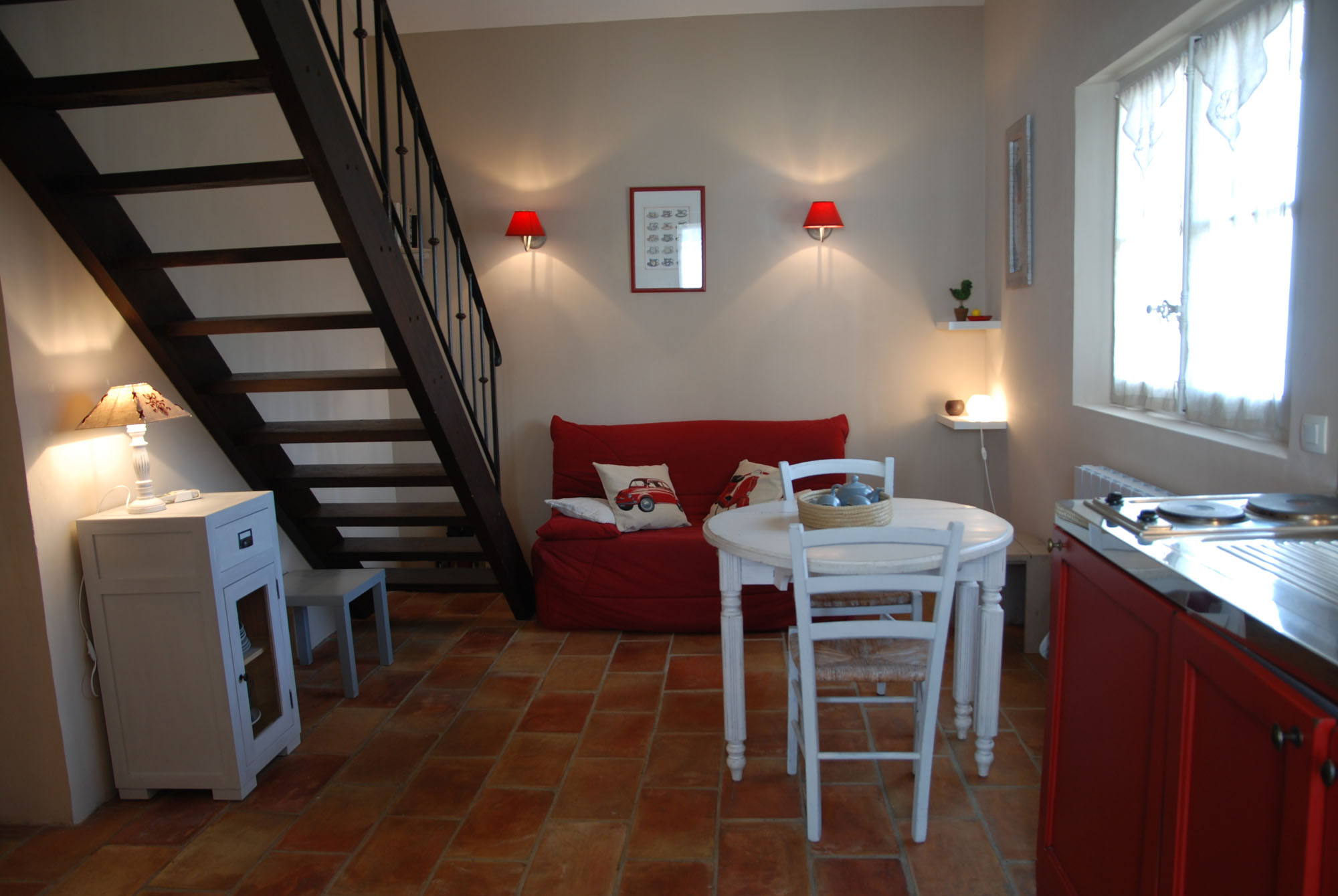 Living area of Le Cocon holiday rental at La Maison Magnarelles Living area of Le Cocon holiday rental with sofa and wooden staircase