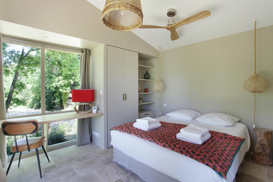 Bright bedroom at Gîte Sénécio in Domaine Les Petites Vaines, featuring a panoramic nature view and minimalist, elegant decor.