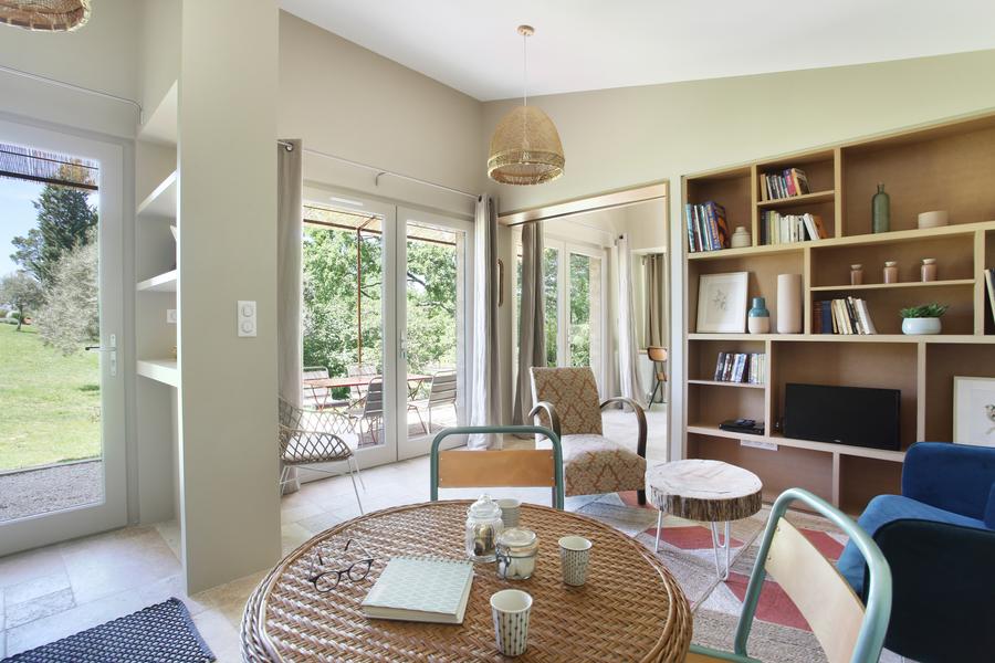 Bright living room at Gîte Senecio in Domaine Les Petites Vaines, cozy space with library and dining area