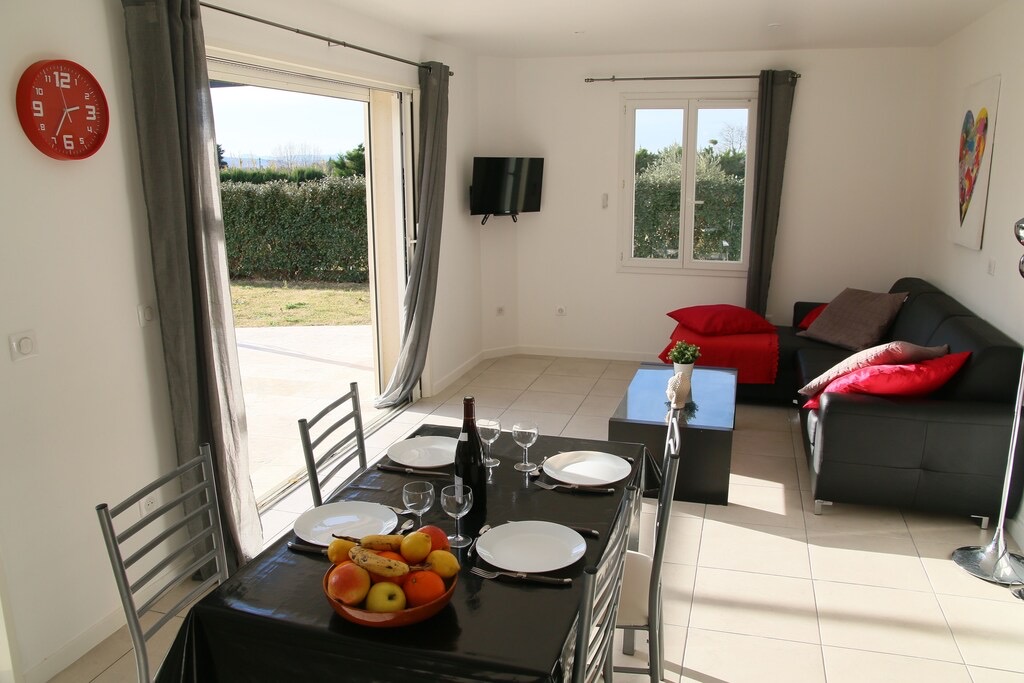 Bright living room and dining area of the villa La Restanque with garden view
