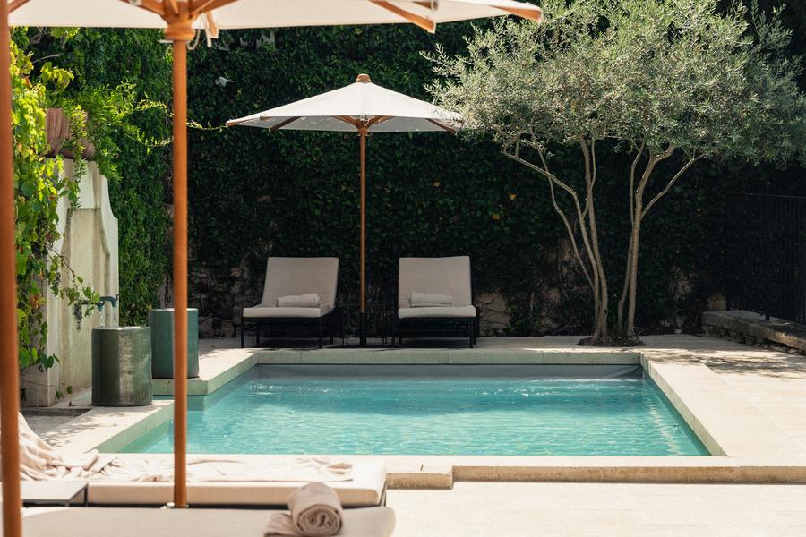 Outdoor swimming pool at Le Moulin in Lourmarin with sun loungers and intimate garden