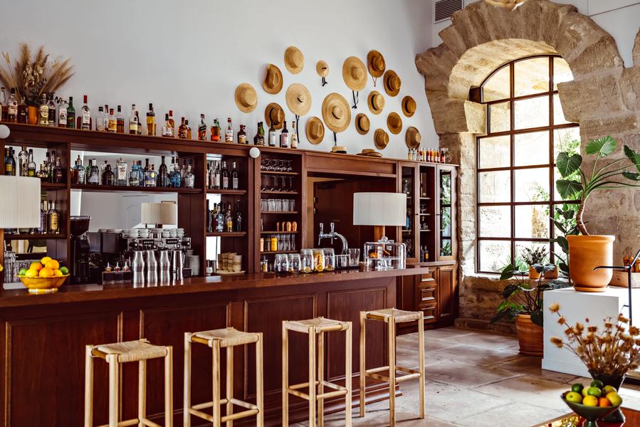 Bar at Le Moulin in Lourmarin with wooden counter and spirits in a Provençal setting