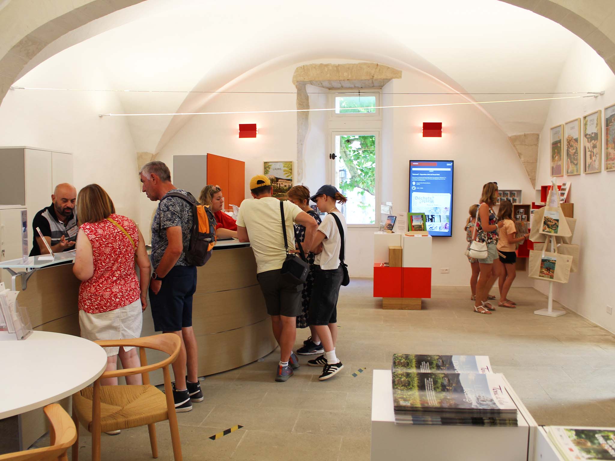 Warm atmosphere at the Destination Luberon Tourist Office in Gordes, with visitors seeking advice and local information.