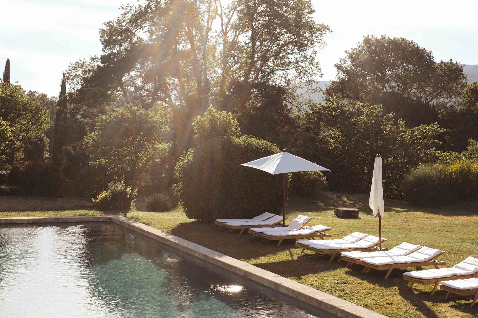 Outdoor swimming pool at Le Galinier with sun loungers in the garden